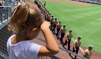 Heartfelt Tribute: Young Girl's Salute to Servicemen Captivates Crowd at Baseball Game